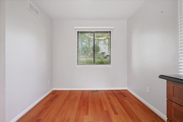 unfurnished room with light wood-style flooring and baseboards