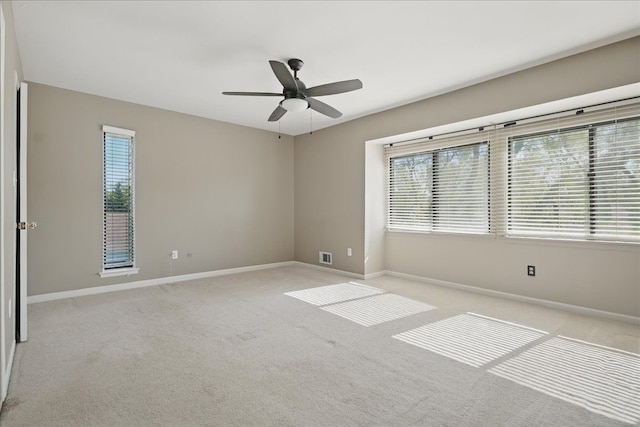 spare room with baseboards, healthy amount of natural light, and ceiling fan