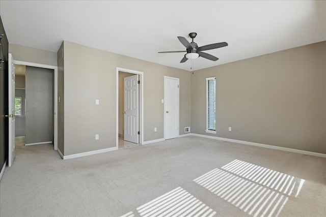 unfurnished bedroom with light colored carpet, baseboards, and a ceiling fan