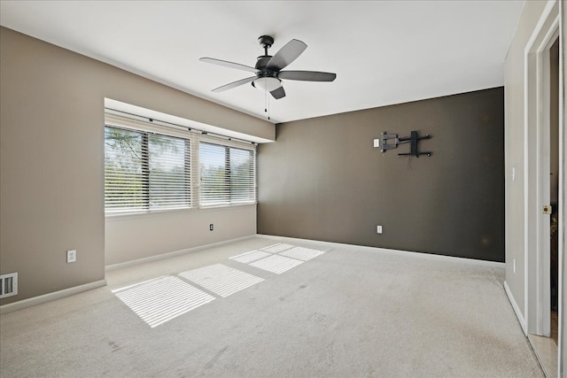 unfurnished room with carpet floors, a ceiling fan, and baseboards