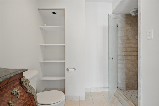 full bath with toilet, tiled shower, tile patterned floors, and vanity