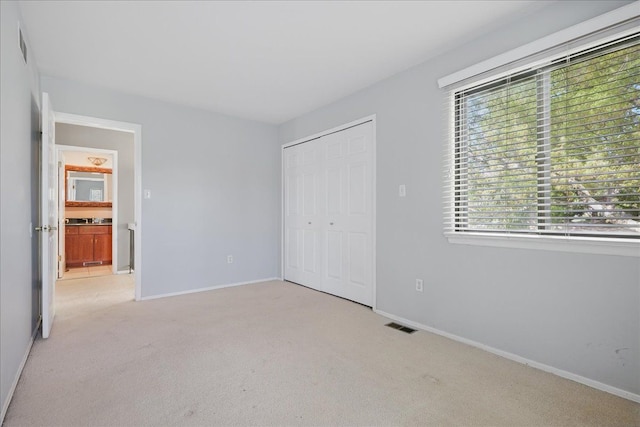 unfurnished bedroom with carpet, a closet, and baseboards