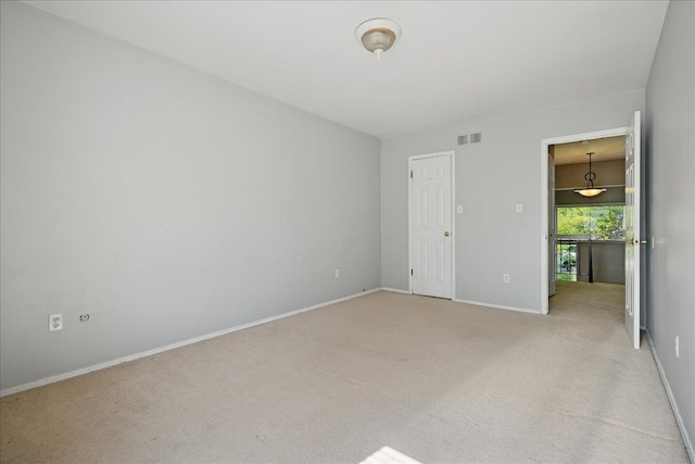 unfurnished bedroom featuring light carpet and baseboards