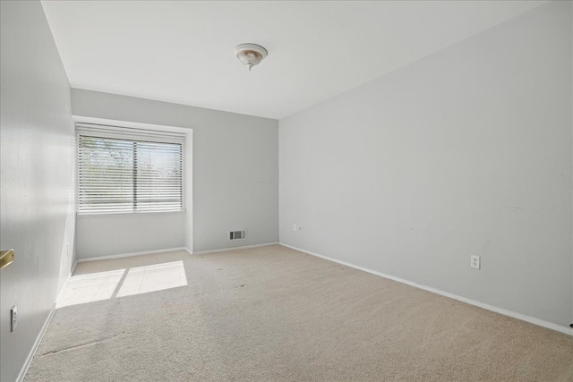 carpeted empty room featuring baseboards