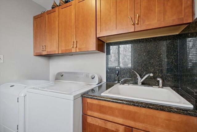 clothes washing area featuring washing machine and dryer and cabinet space