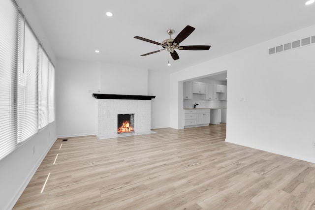 2916 Gladstone St, Detroit, MI 48206 - unfurnished living room featuring light wood finished floors, a fireplace, visible vents, ceiling fan, and recessed lighting