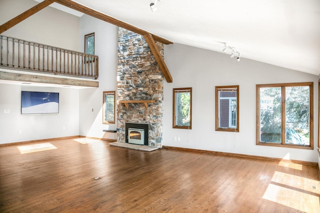24199 N Shore Dr, Edwardsburg, MI 49112 - unfurnished living room featuring a fireplace, wood finished floors, and a healthy amount of sunlight