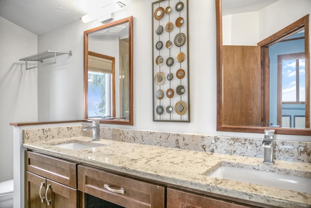 24199 N Shore Dr, Edwardsburg, MI 49112 - bathroom featuring double vanity, a sink, and a healthy amount of sunlight