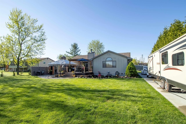 7042 Calkins Rd, Flint, MI 48532 - rear view of property with a gazebo, a lawn, a deck, and a chimney