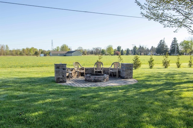 7042 Calkins Rd, Flint, MI 48532 - view of grassy yard featuring a fire pit and a patio area
