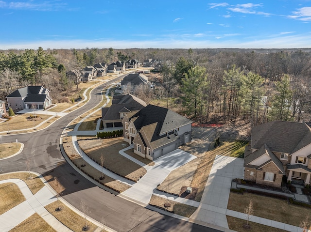 drone / aerial view featuring a residential view and a view of trees