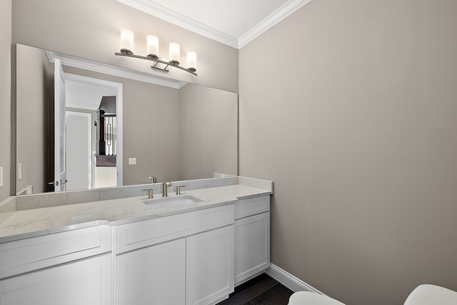 bathroom with crown molding, baseboards, toilet, wood finished floors, and vanity