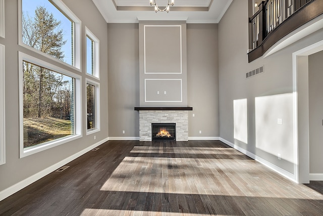 unfurnished living room featuring baseboards, visible vents, and a towering ceiling