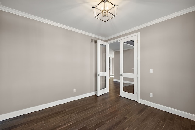 spare room with dark wood-style floors, baseboards, a chandelier, and visible vents
