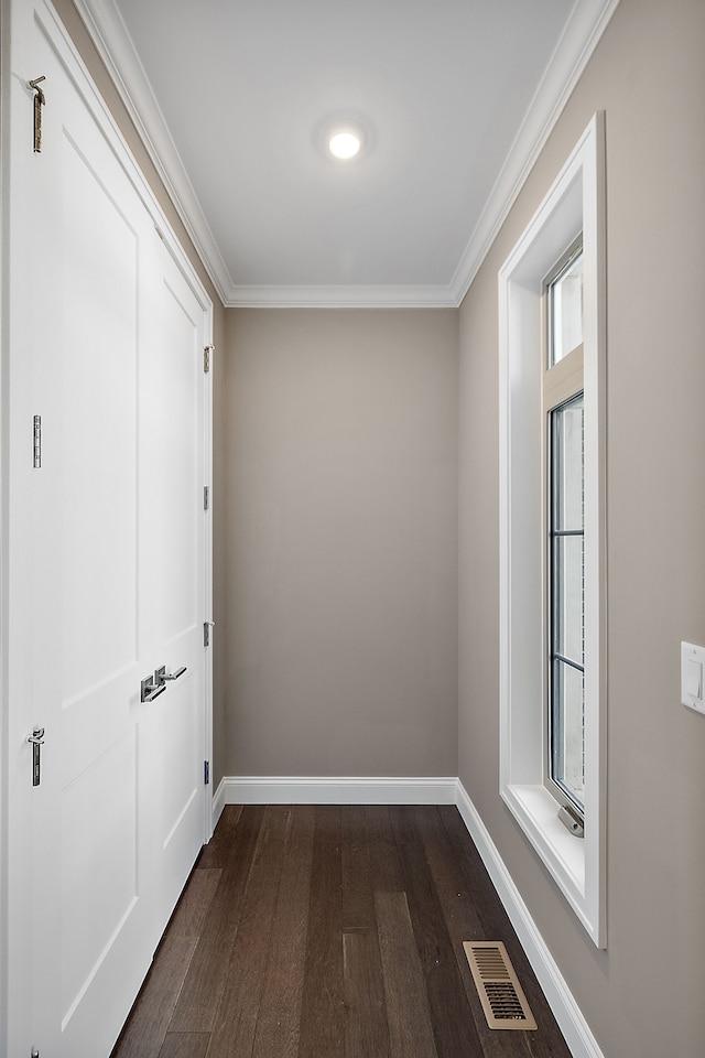 corridor with crown molding, a healthy amount of sunlight, and visible vents