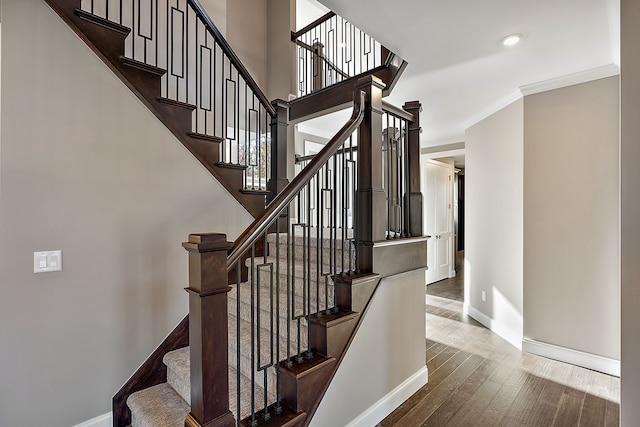 stairs featuring baseboards, ornamental molding, and wood finished floors