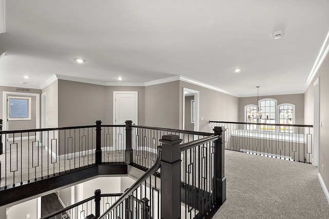 hallway with an inviting chandelier, carpet flooring, an upstairs landing, and crown molding