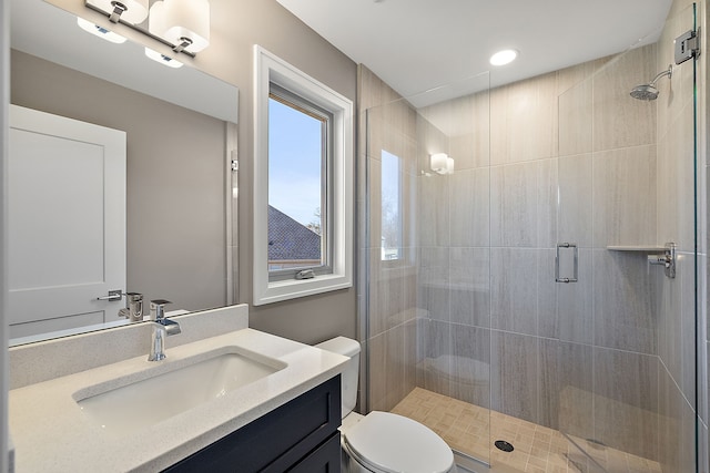 full bath featuring toilet, a stall shower, and vanity