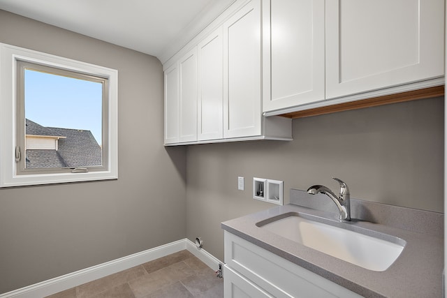 clothes washing area featuring baseboards, washer hookup, cabinet space, and a sink