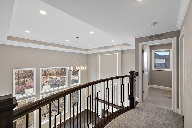 corridor featuring a notable chandelier, visible vents, an upstairs landing, and ornamental molding