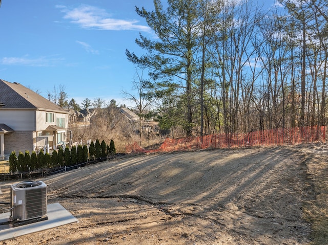view of yard with central AC unit and fence