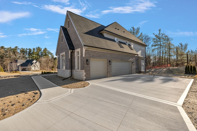 view of property exterior featuring driveway, a shingled roof, an attached garage, and brick siding