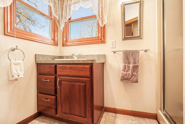 bathroom with baseboards, tile patterned floors, vanity, and an enclosed shower