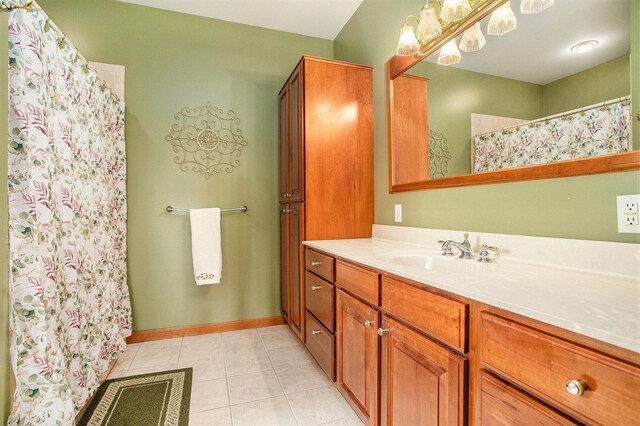 full bath featuring tile patterned flooring, vanity, curtained shower, and baseboards