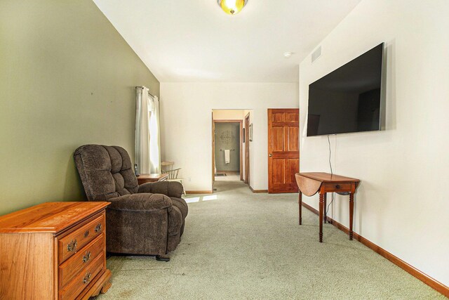 living area with light carpet, baseboards, and visible vents