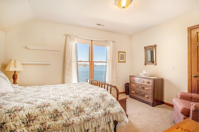 bedroom featuring a water view, visible vents, carpet, baseboards, and lofted ceiling