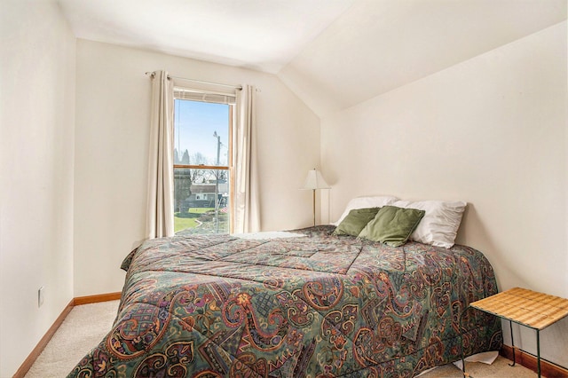 carpeted bedroom with baseboards and lofted ceiling