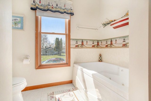 full bath with a tub with jets, tile patterned floors, toilet, and baseboards