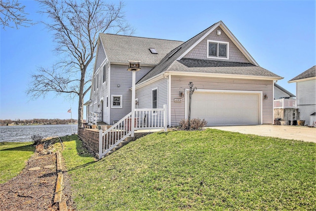 view of front of house with a water view, roof with shingles, concrete driveway, and a front yard