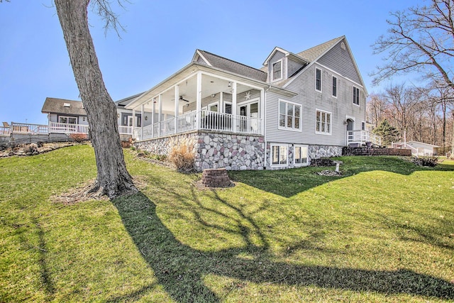 view of side of property featuring a lawn and ceiling fan