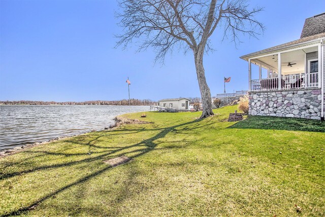 view of yard featuring a water view and a ceiling fan