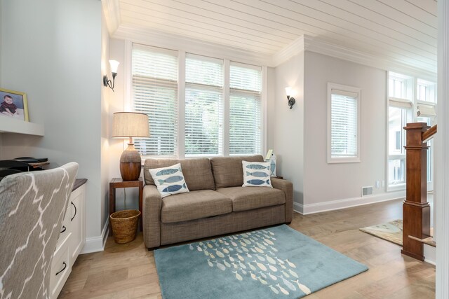 living room with baseboards, visible vents, ornamental molding, and light wood-style flooring