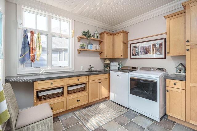 laundry room with washing machine and clothes dryer, cabinet space, ornamental molding, and a sink