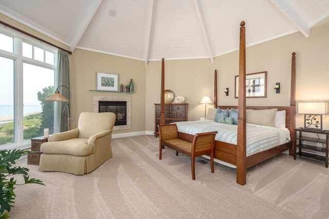 bedroom featuring high vaulted ceiling, beam ceiling, a premium fireplace, baseboards, and light colored carpet