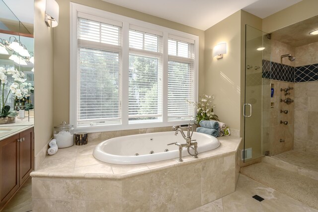 full bathroom with a stall shower, a whirlpool tub, and vanity