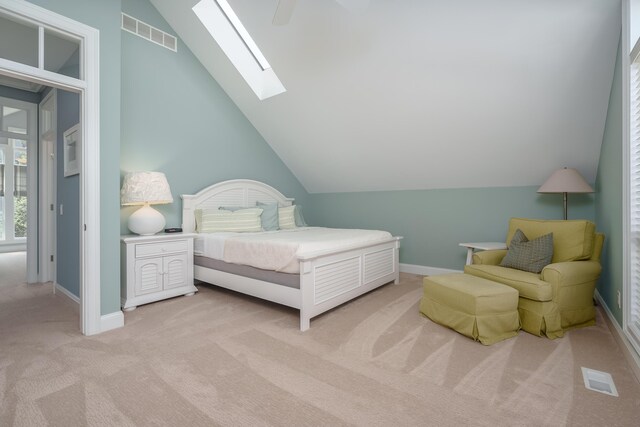 bedroom with lofted ceiling with skylight, carpet, baseboards, ceiling fan, and visible vents