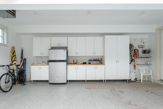 garage with freestanding refrigerator and a sink