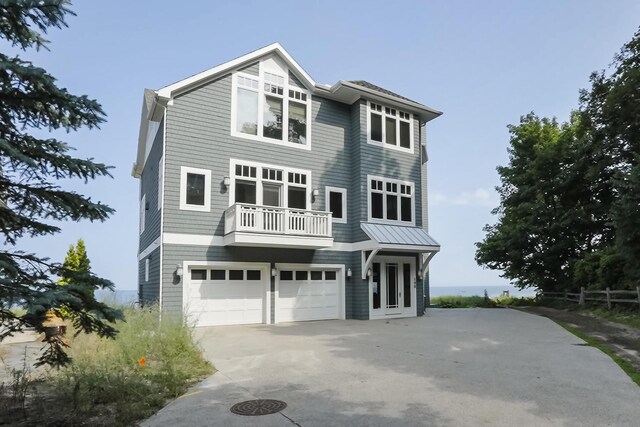 view of front of property featuring a balcony, driveway, and a garage