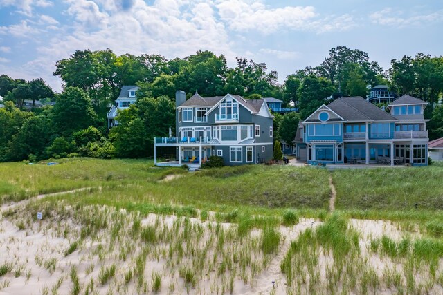 back of property with a balcony and a chimney