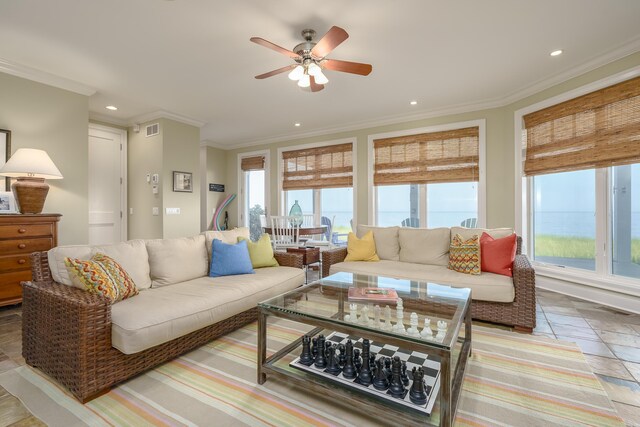 living room featuring a ceiling fan, plenty of natural light, and crown molding