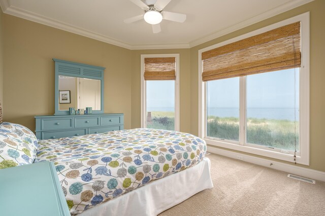 carpeted bedroom featuring crown molding, ceiling fan, and visible vents