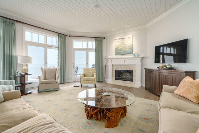 living room featuring wood ceiling, wood finished floors, a premium fireplace, baseboards, and ornamental molding