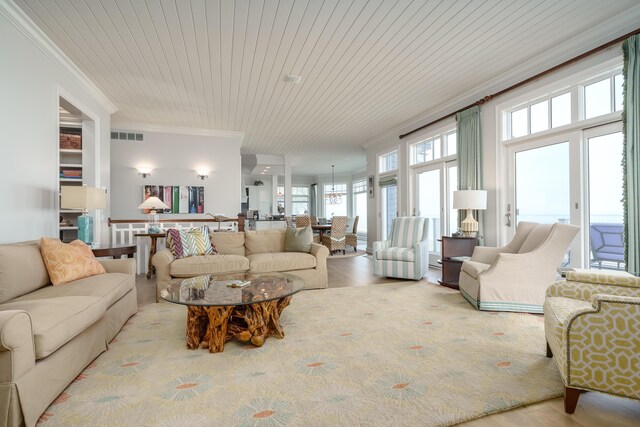 living area featuring visible vents, wood finished floors, wood ceiling, and ornamental molding