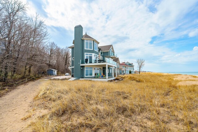 back of property with a balcony and a chimney