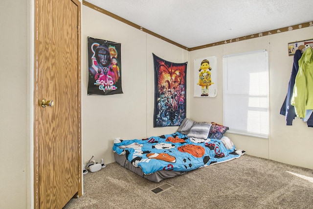 carpeted bedroom featuring a textured ceiling and visible vents