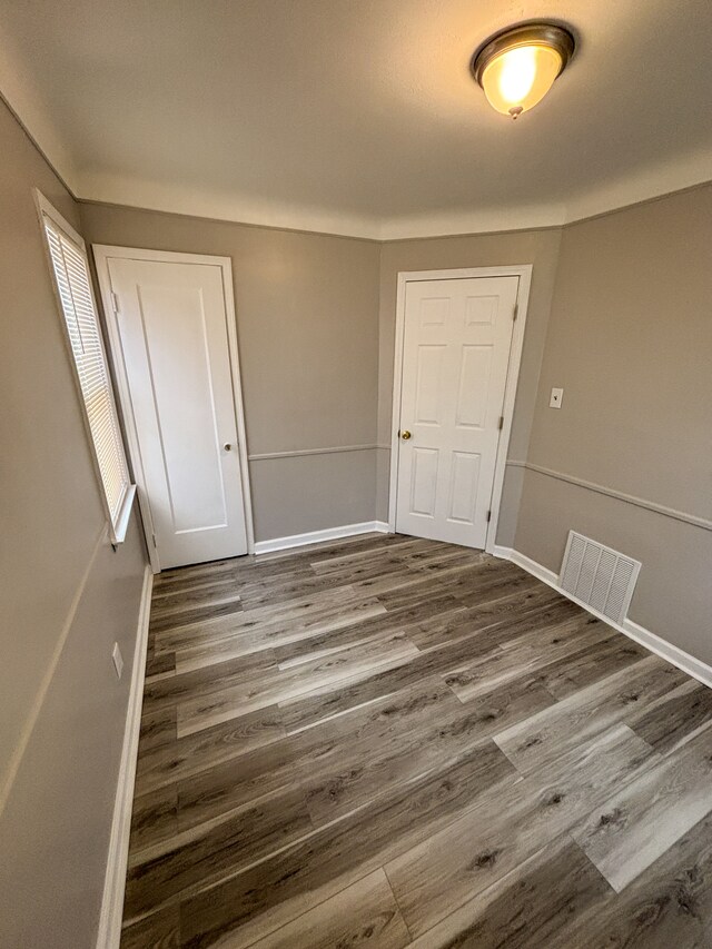 18484 Ashton Ave, Detroit, MI 48219 - spare room featuring baseboards, dark wood-style floors, and visible vents